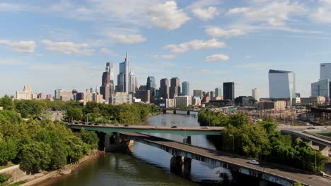 slow rising and dolly forward tracking drone shot above schuylkill river, flying toward city of philadelphia pennsylvania skyline