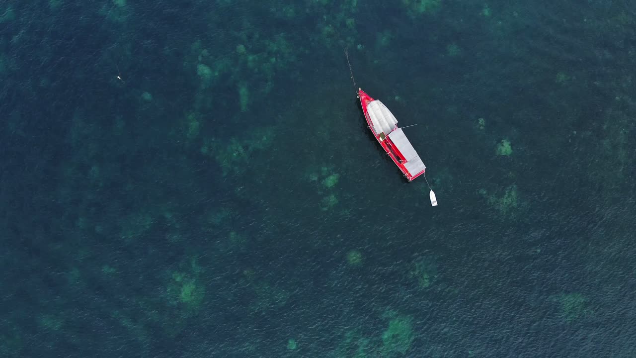 fotografía de un avión no tripulado de arriba hacia abajo de un barco rojo en tailandia con coral bajo el agua