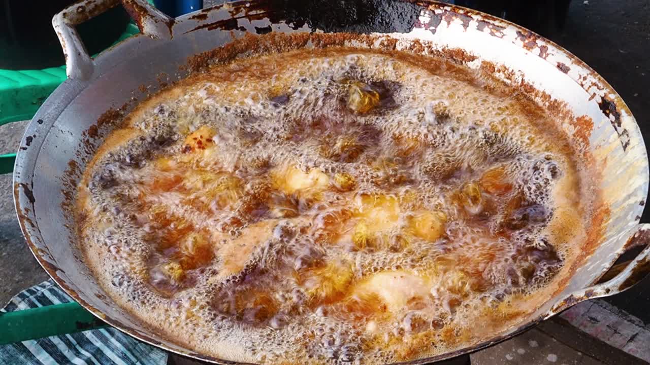 pollo frito en aceite caliente en el mercado callejero