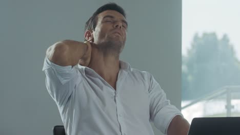 hombre de negocios tratando de relajarse en un lugar de trabajo remoto. hombre cansado trabajando en una computadora portátil.