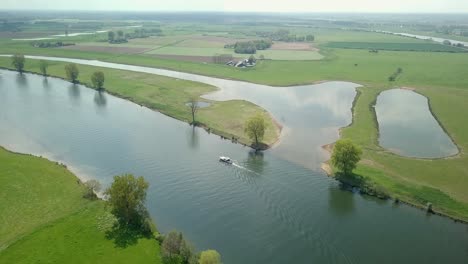 vista aérea de un dron sobrevolando el lago y revelando que un barco está pasando en los países bajos