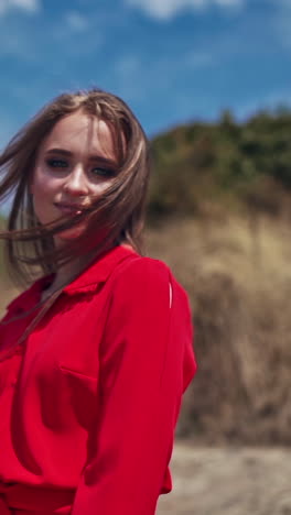 portrait of a smiling girl outdoors. beautiful young woman looking at camera. happy attractive female with long hair standing in nature. vertical video