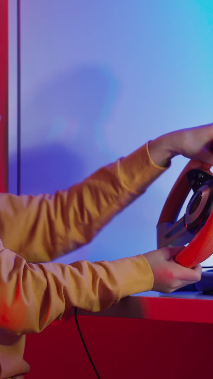 Gamer plays video game. Girl with joystick playing racing game in room at night. Vertical video