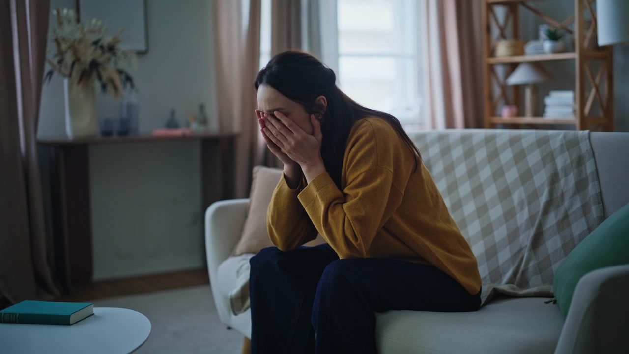 Lady disappointed smartphone notification sitting couch. Worried woman reading