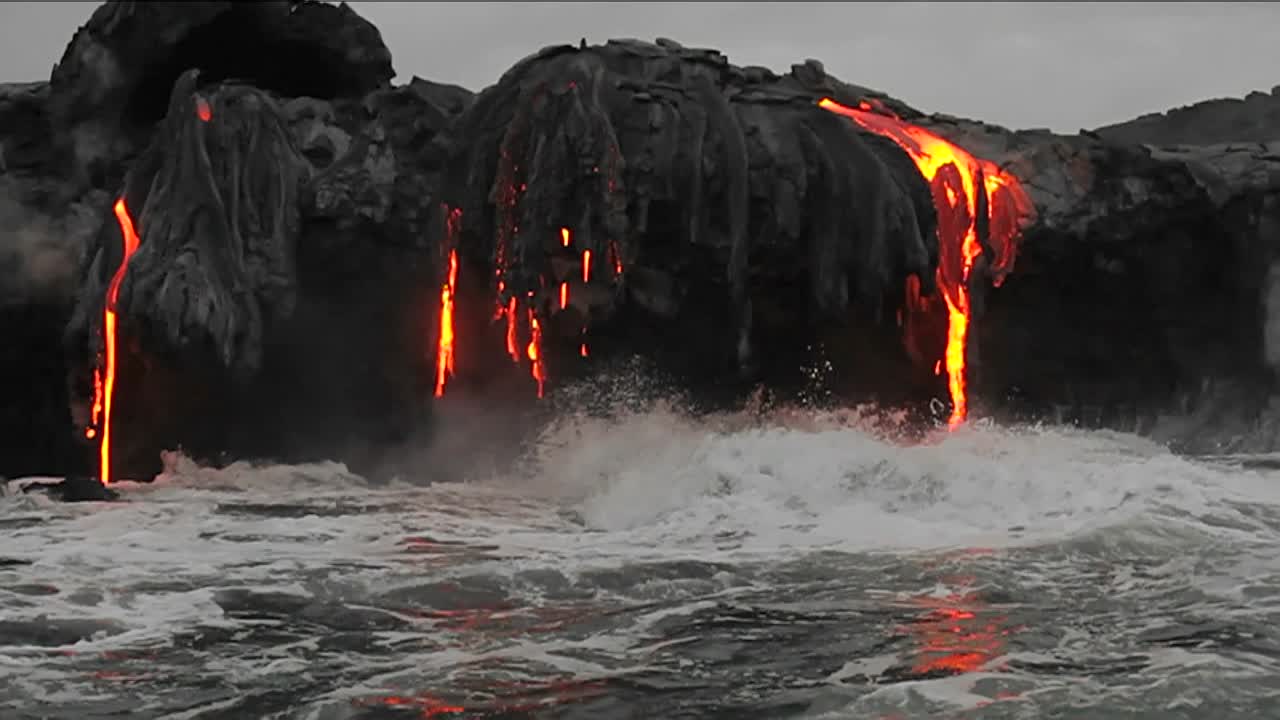 el espectacular flujo de lava del atardecer desde un volcán hacia el océano sugiere el nacimiento del planeta