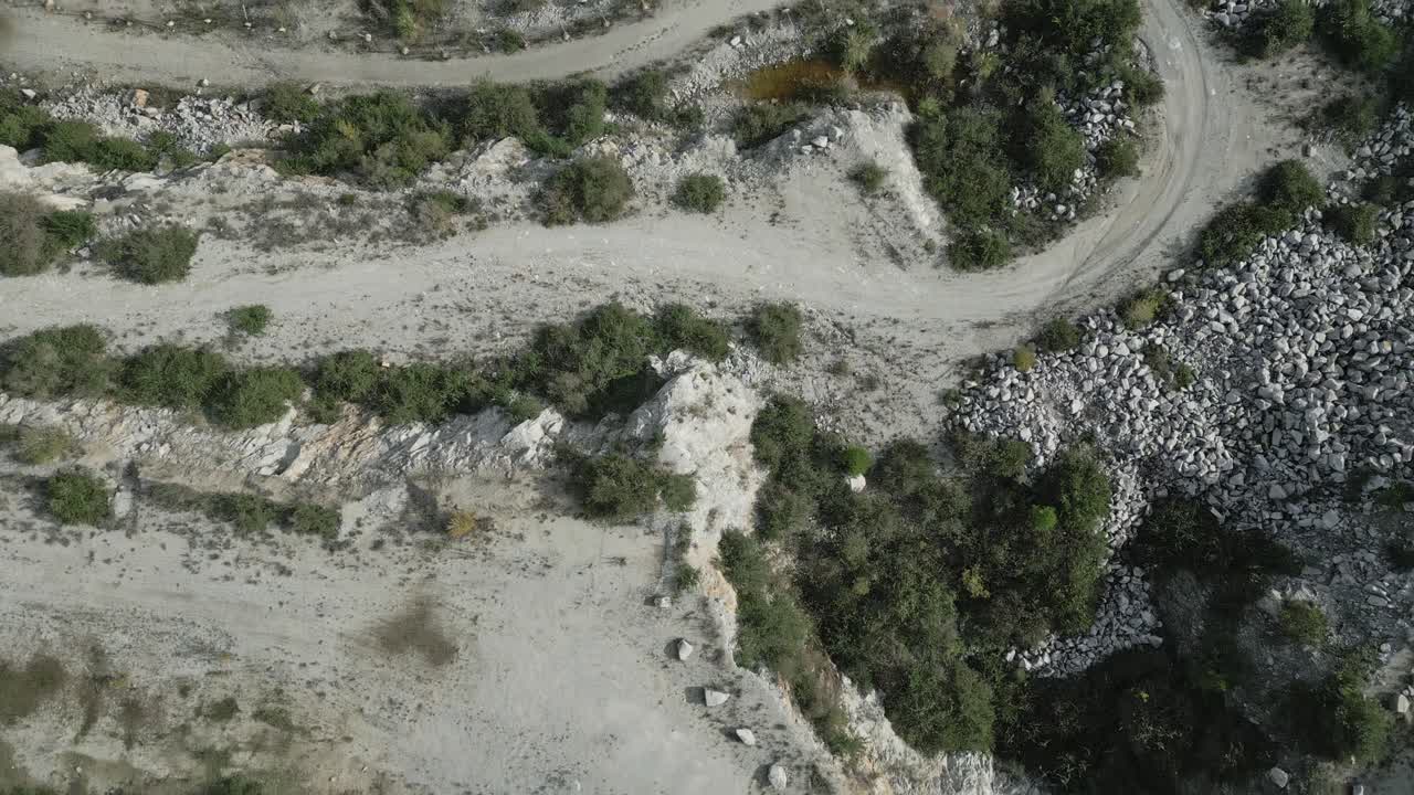 Green water gradually filling quarry basin, transforming mining landscape into emerging lake through sequential aerial perspectives revealing environmental change and resource reclamation process