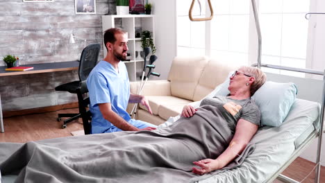 male nurse visit old woman lying in bed