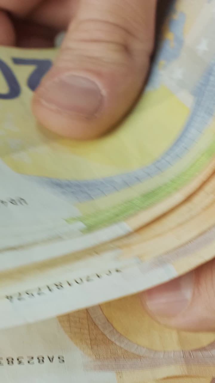 Primo piano di mani che contano e sfogliano banconote in euro