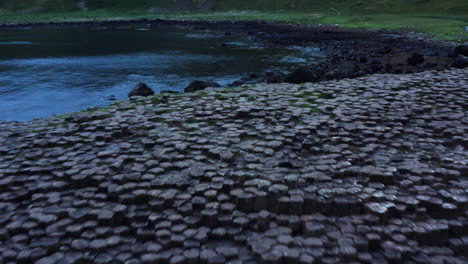 giant's causeway basalt columns, ancient rock formation, aerial drone flyover