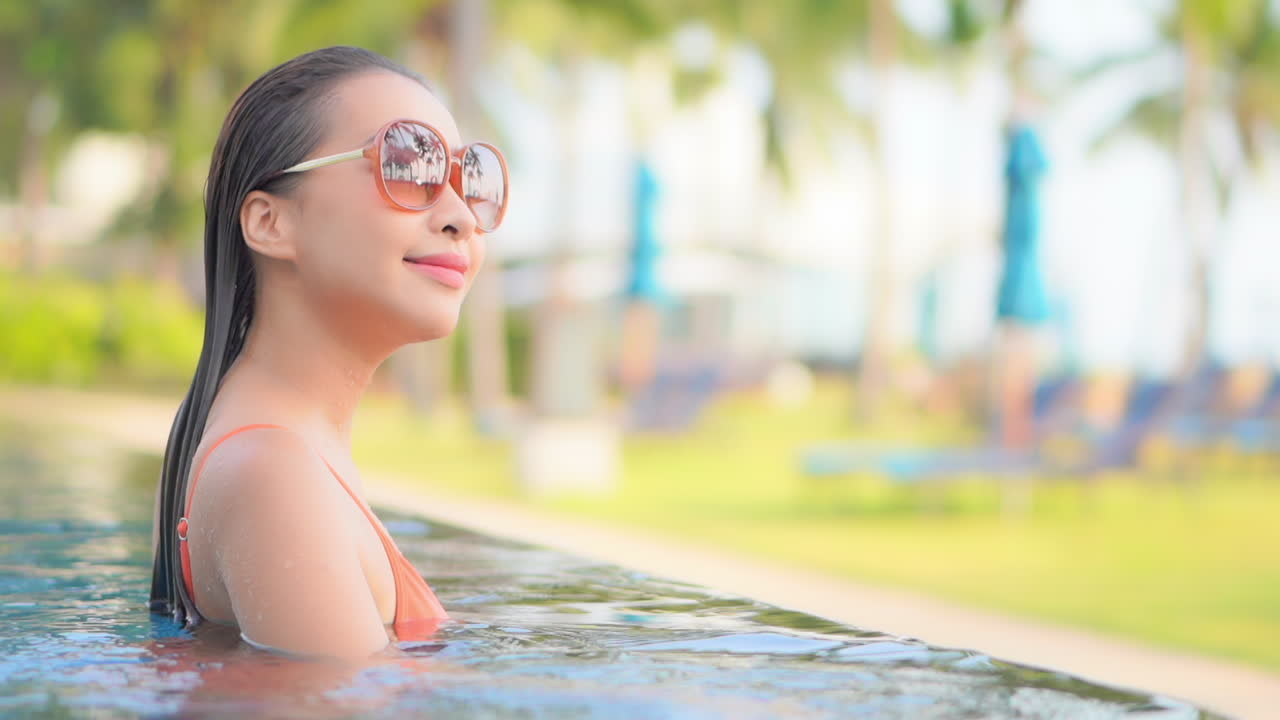 수영장 가장자리로 걸어가는 열대 환경에 있는 여성의 클로즈업