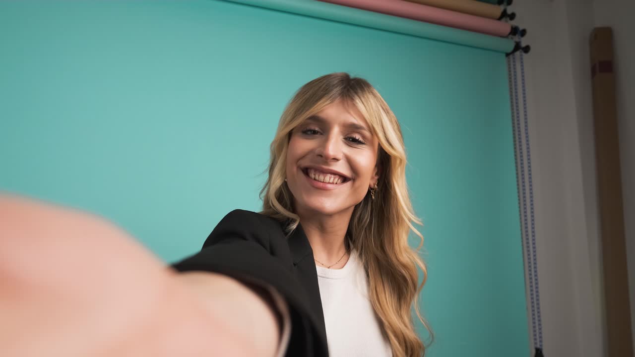 Happy transgender businesswoman puckering lips while taking selfie in studio