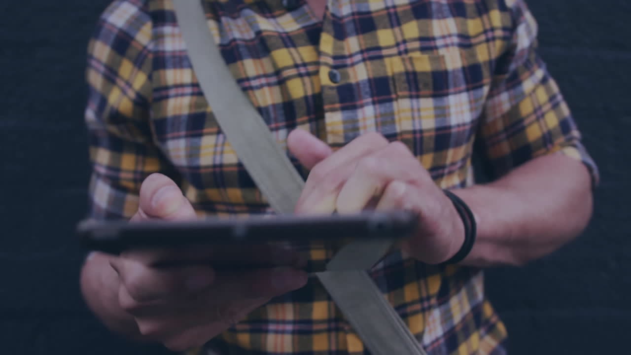 Using tablet, person in plaid shirt walking outdoors with animation on screen