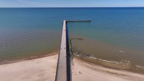 Aerial-view-a-bridge-standing-on-the-beach-of-Palanga,-which-goes-to-the-Baltic-Sea