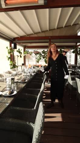 restaurant staff setting tables for outdoor dining