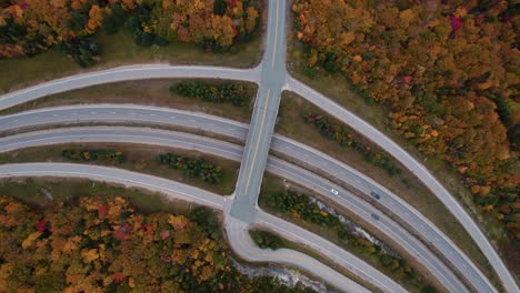 top down aerial of a highway road in the mountains during the fall