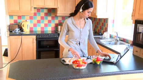 mujer moderna preparando una ensalada y comunicándose en internet