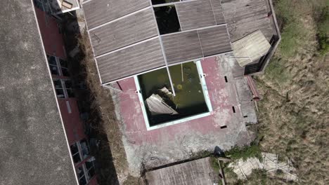 imágenes aéreas de drones de arriba hacia abajo que se elevan y giran sobre una piscina cubierta abandonada y un hotel