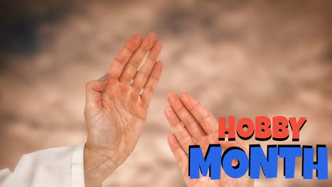 animation of hobby month text in red and blue over hands of female and male martial artist