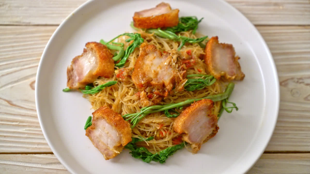 Stir-fried rice vermicelli and water mimosa with crispy pork belly