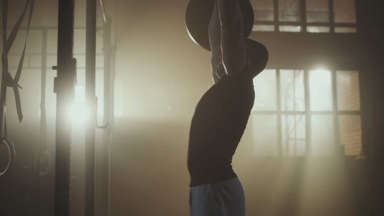 Mand løfter vægte i et fitnesscenter
