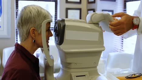 optometrist examining patient eyes with autorefractors 4k