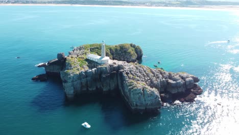 Hermoso-Faro-En-Una-Isla-Con-Aguas-Azules-En-Un-Día-Soleado