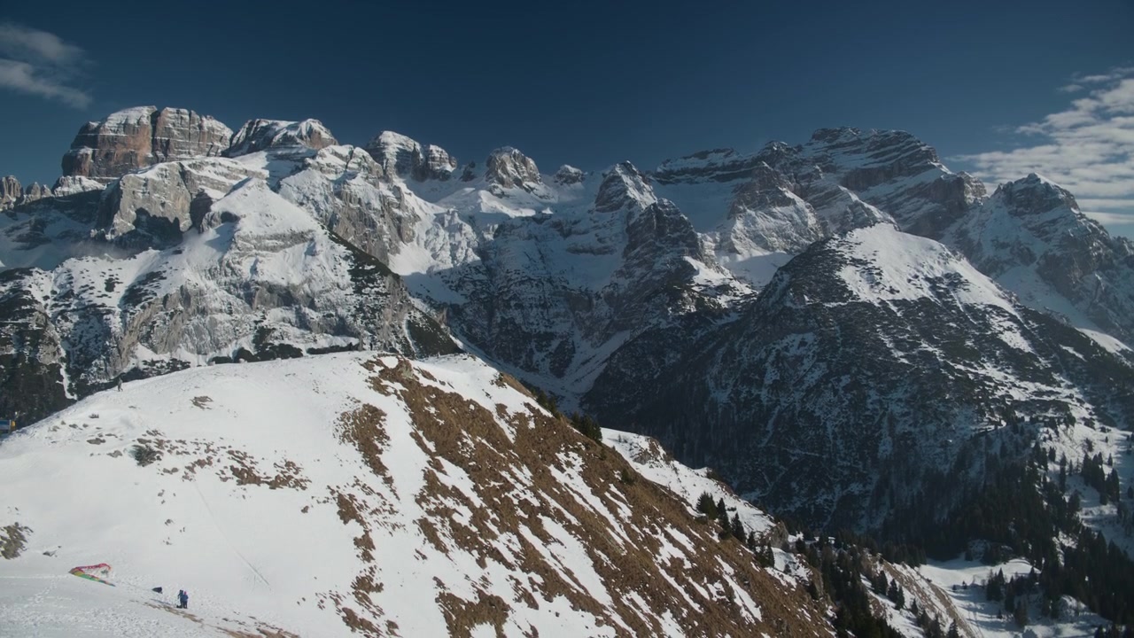 Paesaggio invernale di catena montuosa innevata con panning, ripresa a mano. Vista panoramica di cime alpine ad alta quota coperte di ghiaccio bianco sotto il cielo