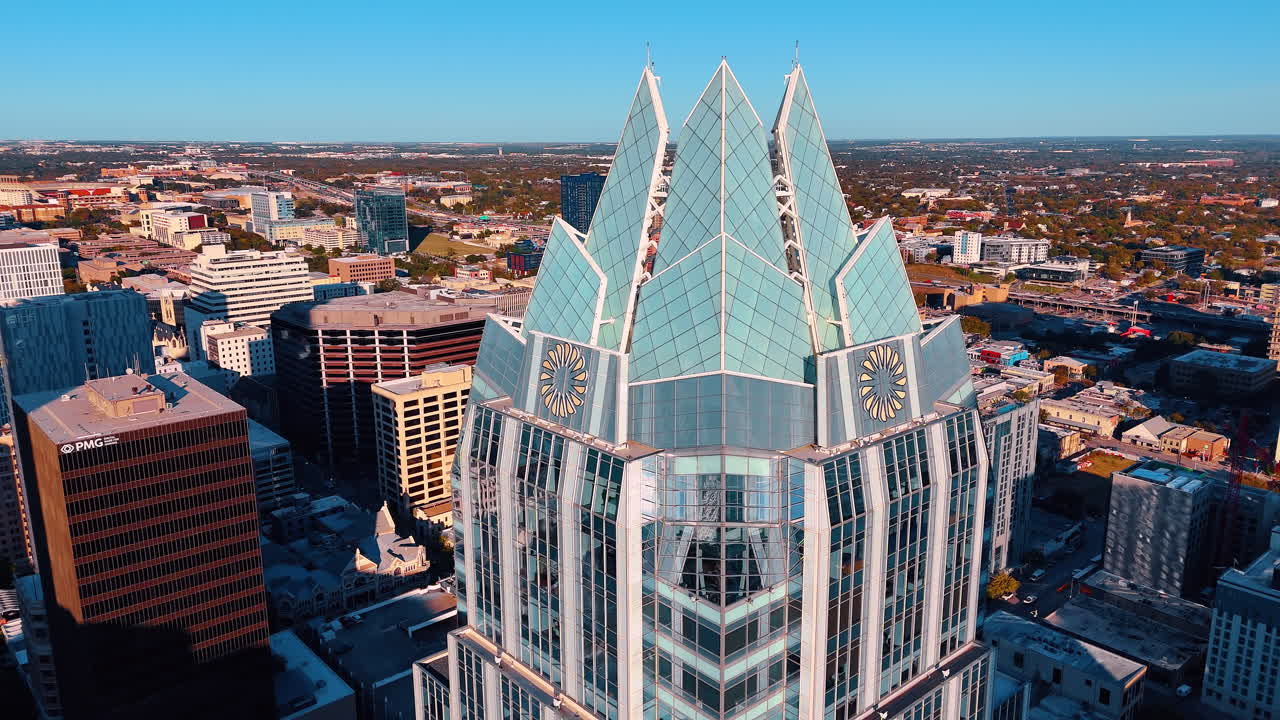 Austin, USA, 21 novembre 2025: Vista dettagliata della cima architettonica di un grattacielo ad Austin, Texas. Foto aerea diurna della cima di un grattacielo di vetro con motivi geometrici contro un cielo azzurro e limpido ad Austin.
