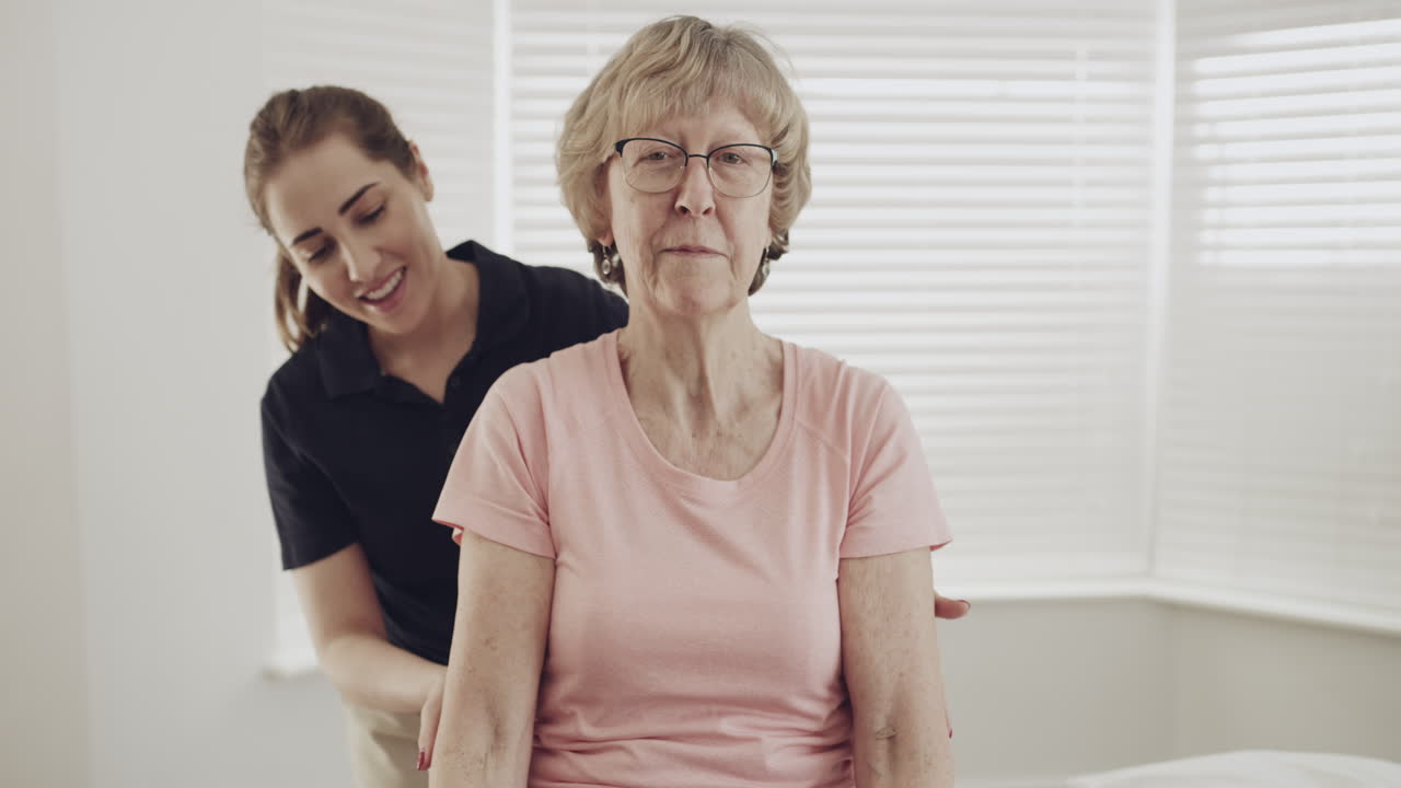 여성 물리 치료사가 노인을 돕고 있습니다.