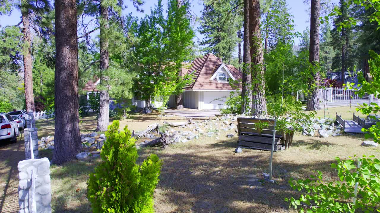 Drone flying through trees towards a home in the forest of Wrightwood California