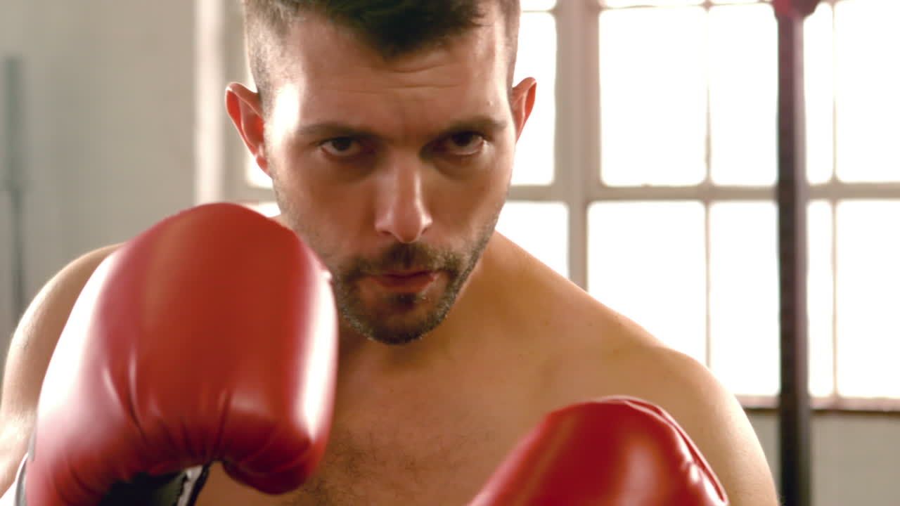 체육관 에서 카메라 를 향해 권투 하는 건강 한 남자