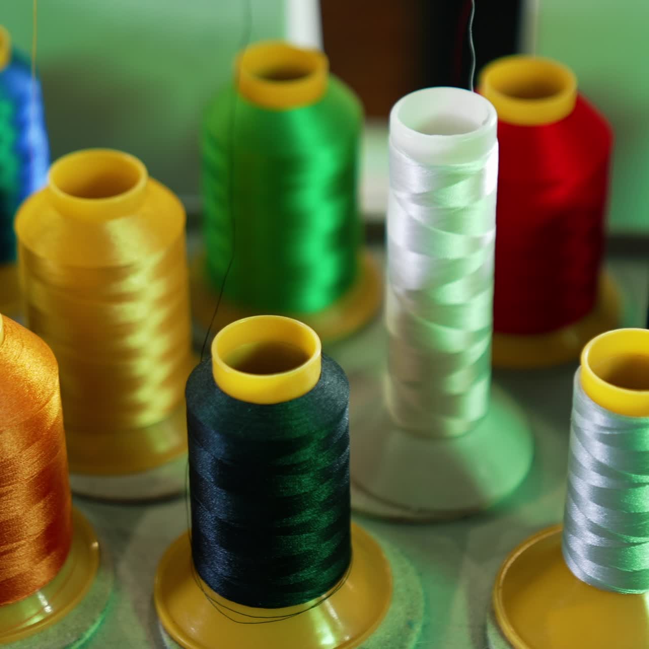 Threads in spools for dressmaker. Collection of colorful threads. Sewing tools. Background of colorful bobbins. Close-up. Hobbies and handicraft concept