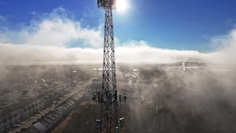 an aerial view of a neighborhood and cell tower in south carolina covered by clouds.