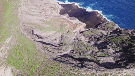 las imágenes de drones comienzan en un gran cráter en una formación volcánica en la costa de oahu en las islas hawaianas y respaldo para revelar la isla rodeada por el agua azul del océano pacífico.