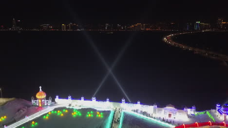 Luces-De-Búsqueda-Barren-El-Cielo-Nocturno-En-El-Festival-De-Hielo-En-Harbin-China,-Antena