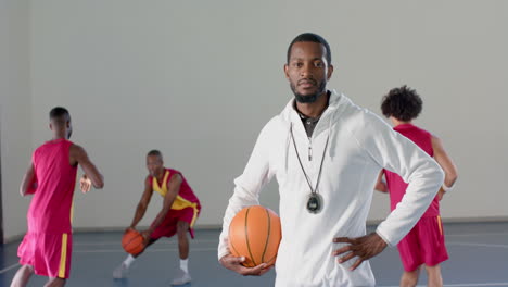 african american coach stands confidently with a basketball