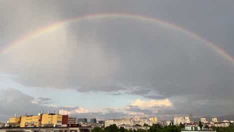 pan shot of a rainbow over the city of sofia, bulgaria, in the summer