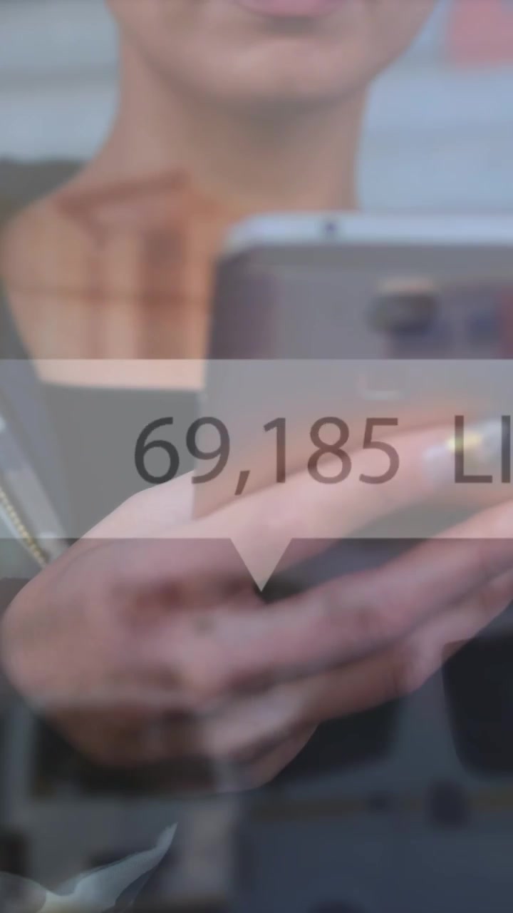 Animation of like icons with increasing numbers against mid section of woman using smartphone