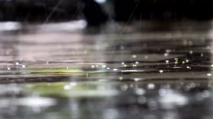 Close up video footage of rain drops falling down water surface of marble surface splashing with ripple during heavy raindrop, wet rainy weather nature background, audio included