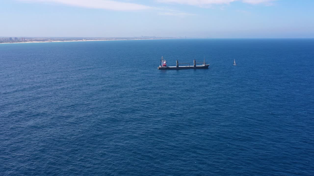 buque de carga y velero en el mar
