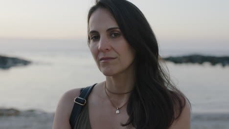 portrait of confident elegant woman on calm peaceful beach looking sophisticated slow motion