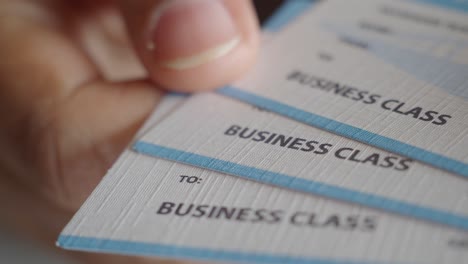 close up of a person holding business class airline tickets