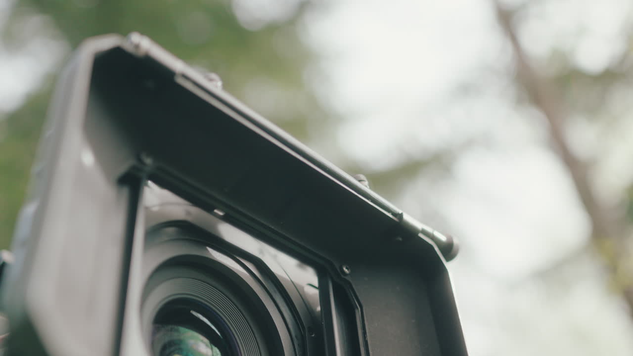 Caucasian hand inserting and removing square ND filter from matte box, close-up