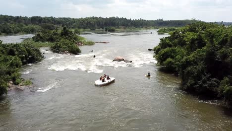 aerial drone view of an upside down rafting boat with people on top of it on the nile river in jinja, uganda