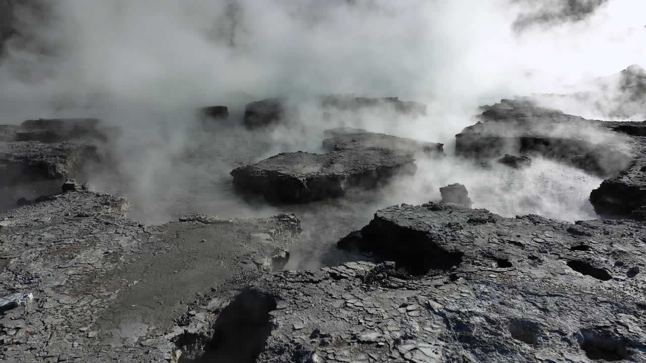 Drone slowly flying low over geothermal landscape. Trees, steam, bubbling mud and steam. Alien Landscape. Sci-fi. Global Warming