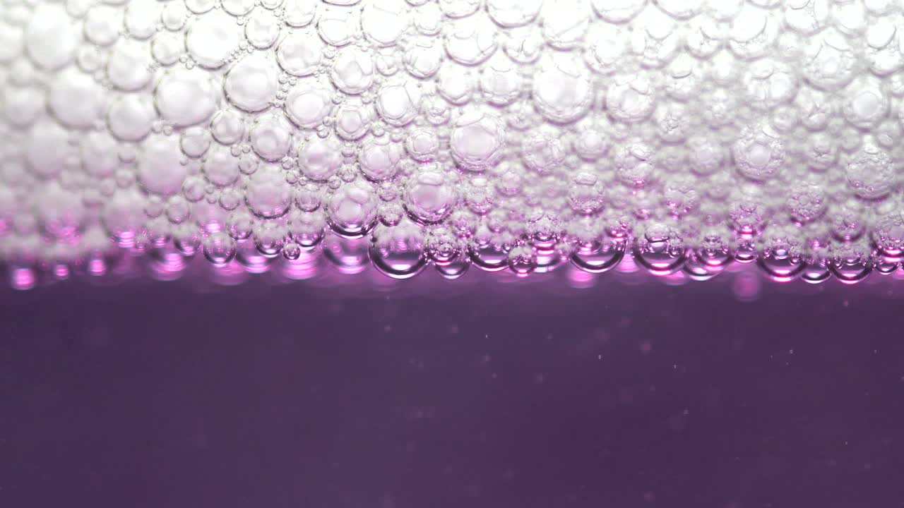 primer plano de pompas de jabón en un líquido púrpura