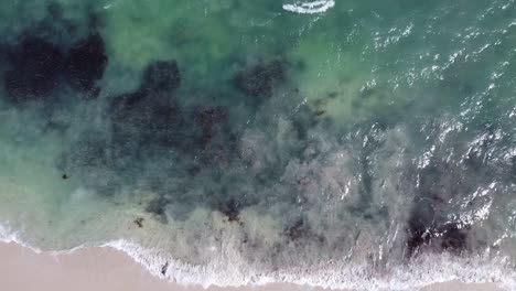 Under-the-surface-of-an-incoming-tide-sand-moves-clouding-the-clear-ocean-water