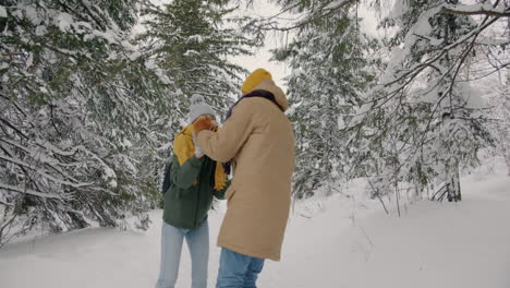 couple enjoying a winter walk in the snow-covered forest