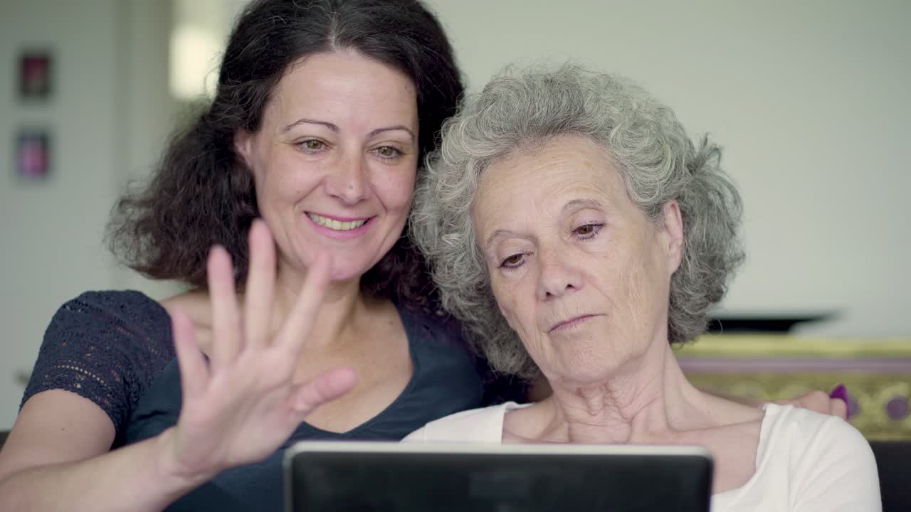 Figlia e madre che tengono un tablet, cercano su Google e scorrono le foto