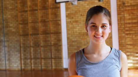 Schoolgirl-standing-with-basketball-in-court-4k